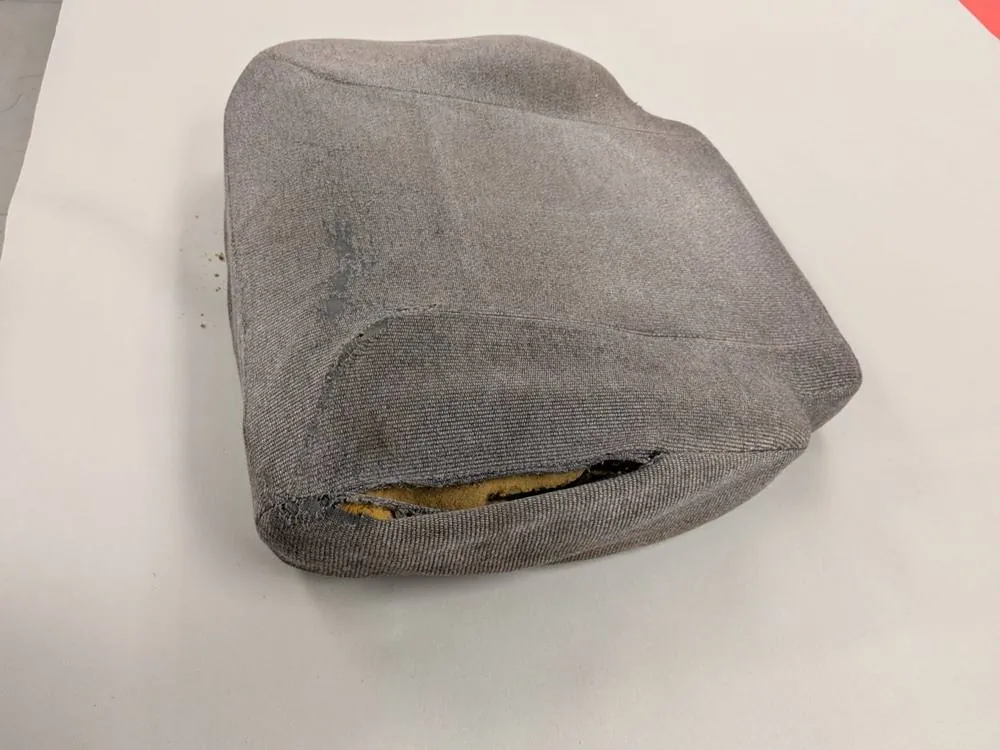 Before: Worn gray seat cushion with a hole and exposed foam